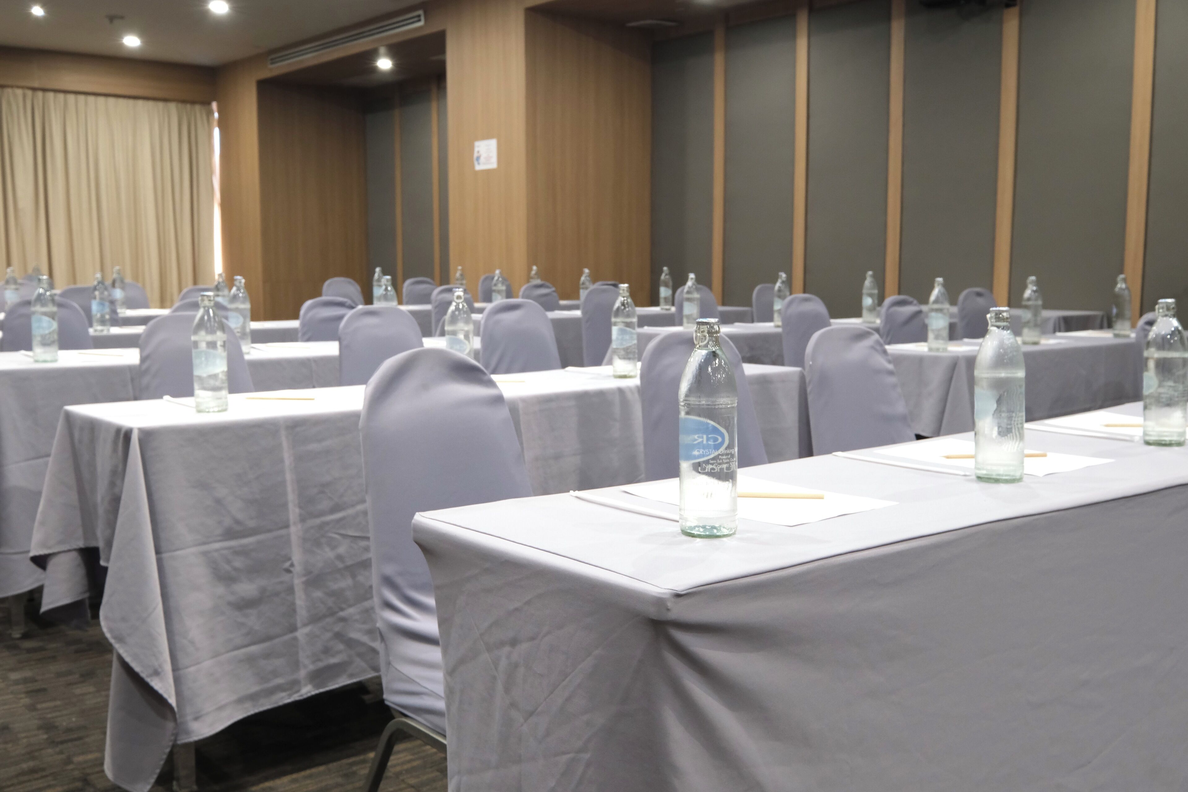 A conference room with tables set up for meetings, each with water bottles and nameplates.