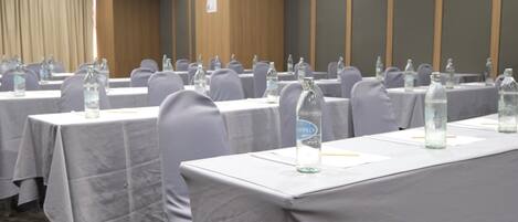 A conference room with tables set up for meetings, each with water bottles and nameplates.