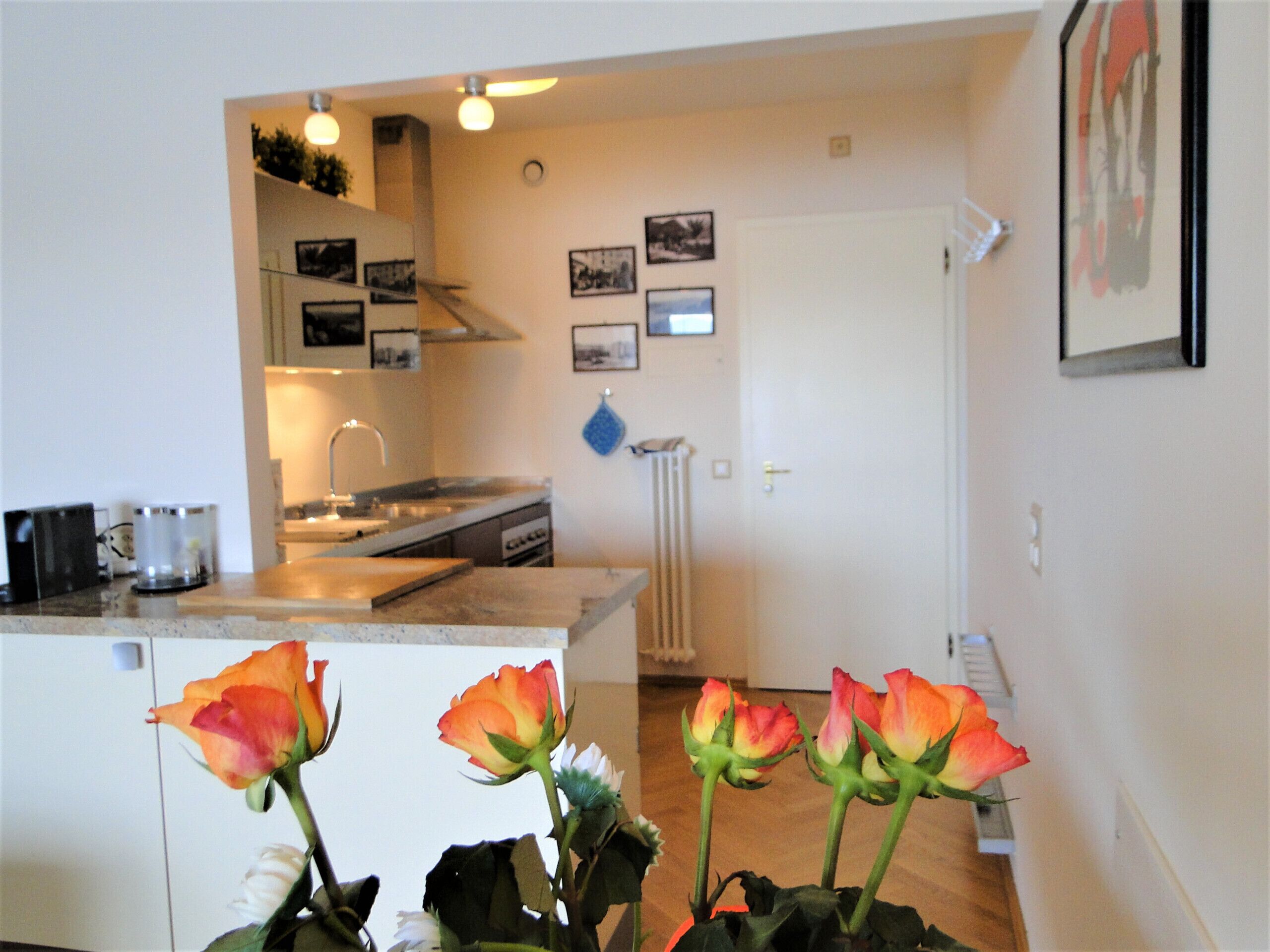 Una cocina con mostrador, pileta y una puerta que da a otra habitación.