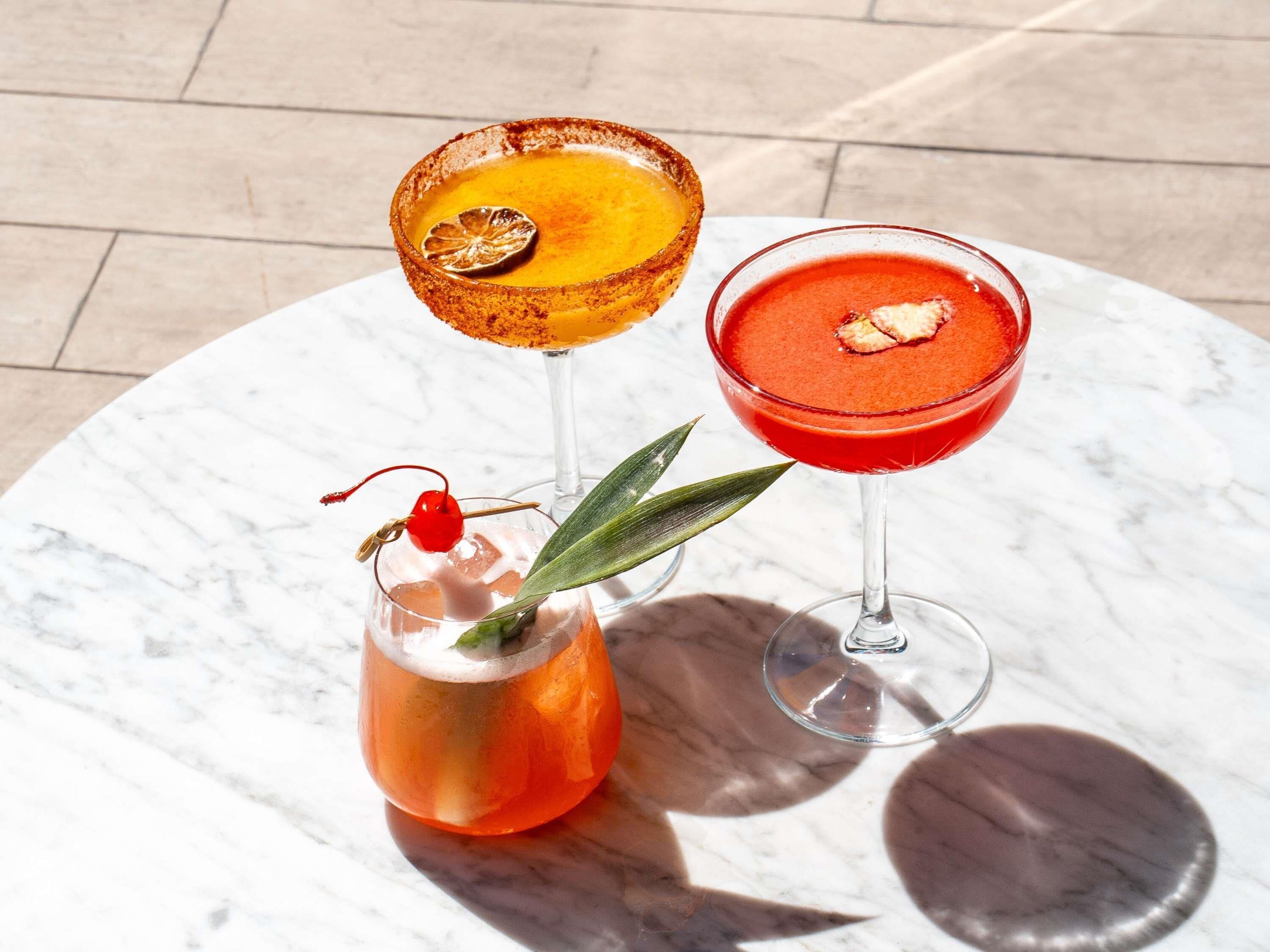 Tres bebidas sobre una mesa de mármol.