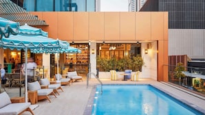 A rooftop pool area with lounge chairs, umbrellas, and a bar. - The Adnate Perth - Art Series (Perth)