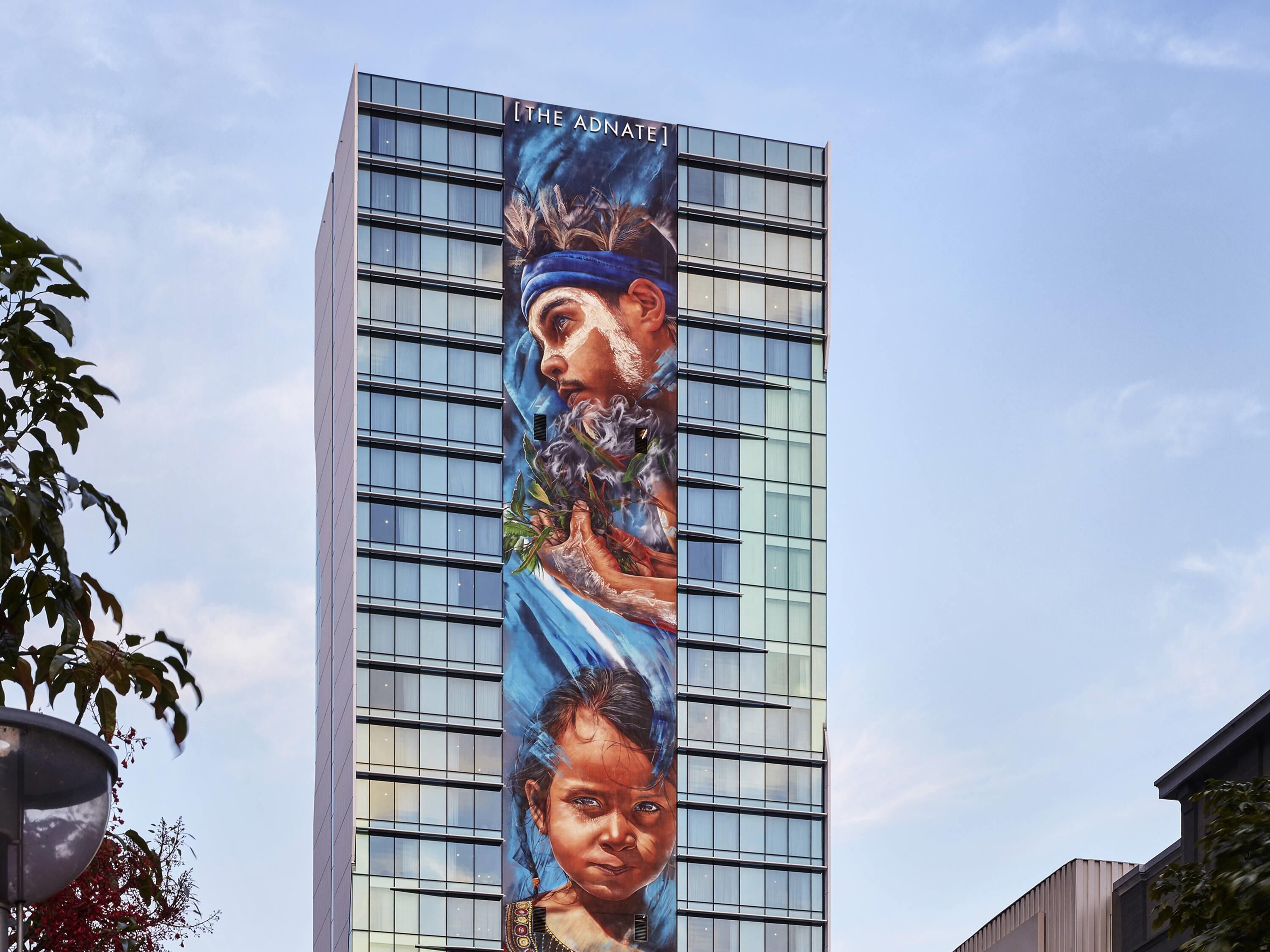 A tall building with a large mural on its side.