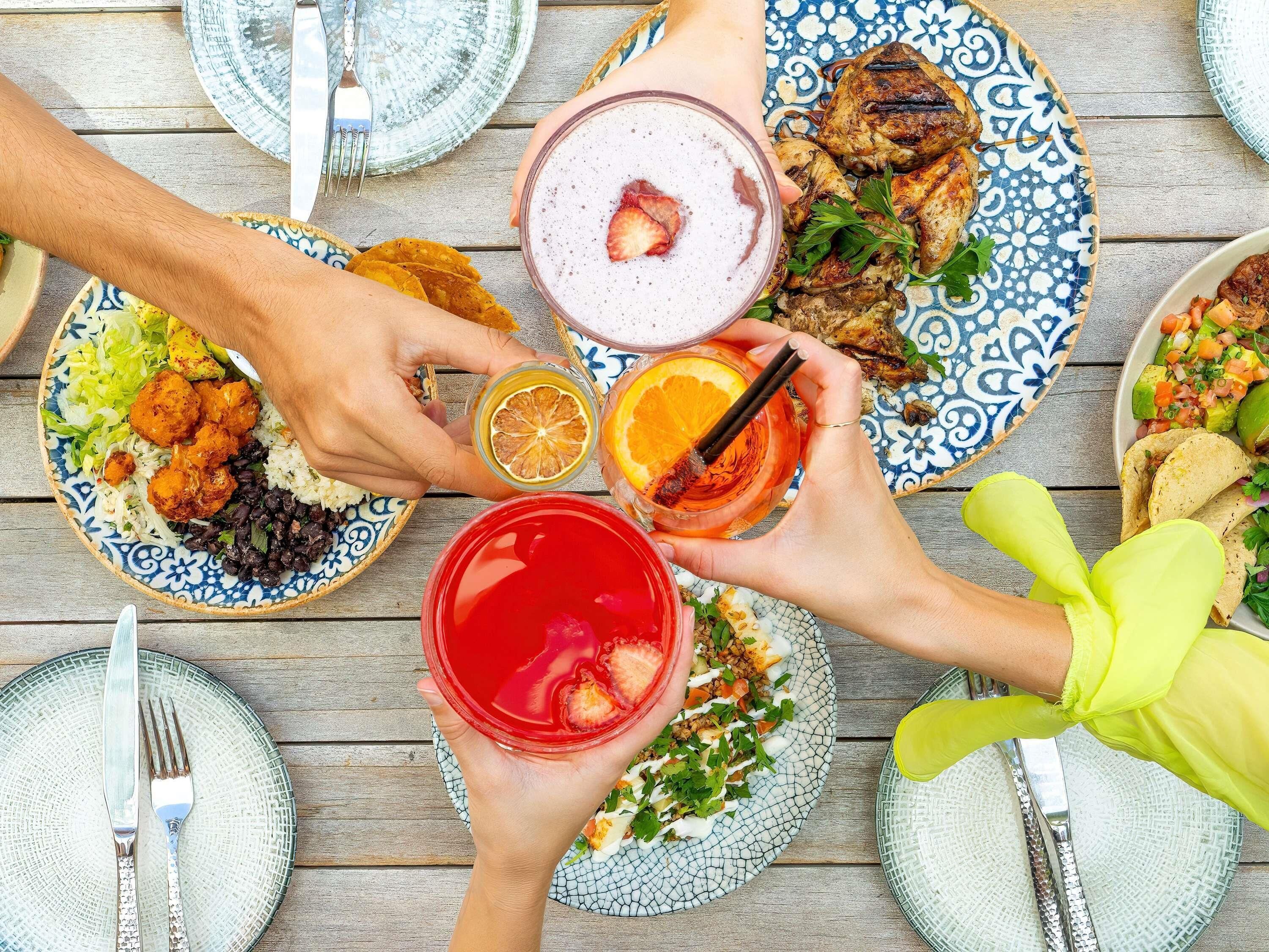 Una mesa con diferentes platos, bebidas y cubiertos.
