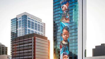 A modern high-rise building with a large vertical advertisement featuring a person.
