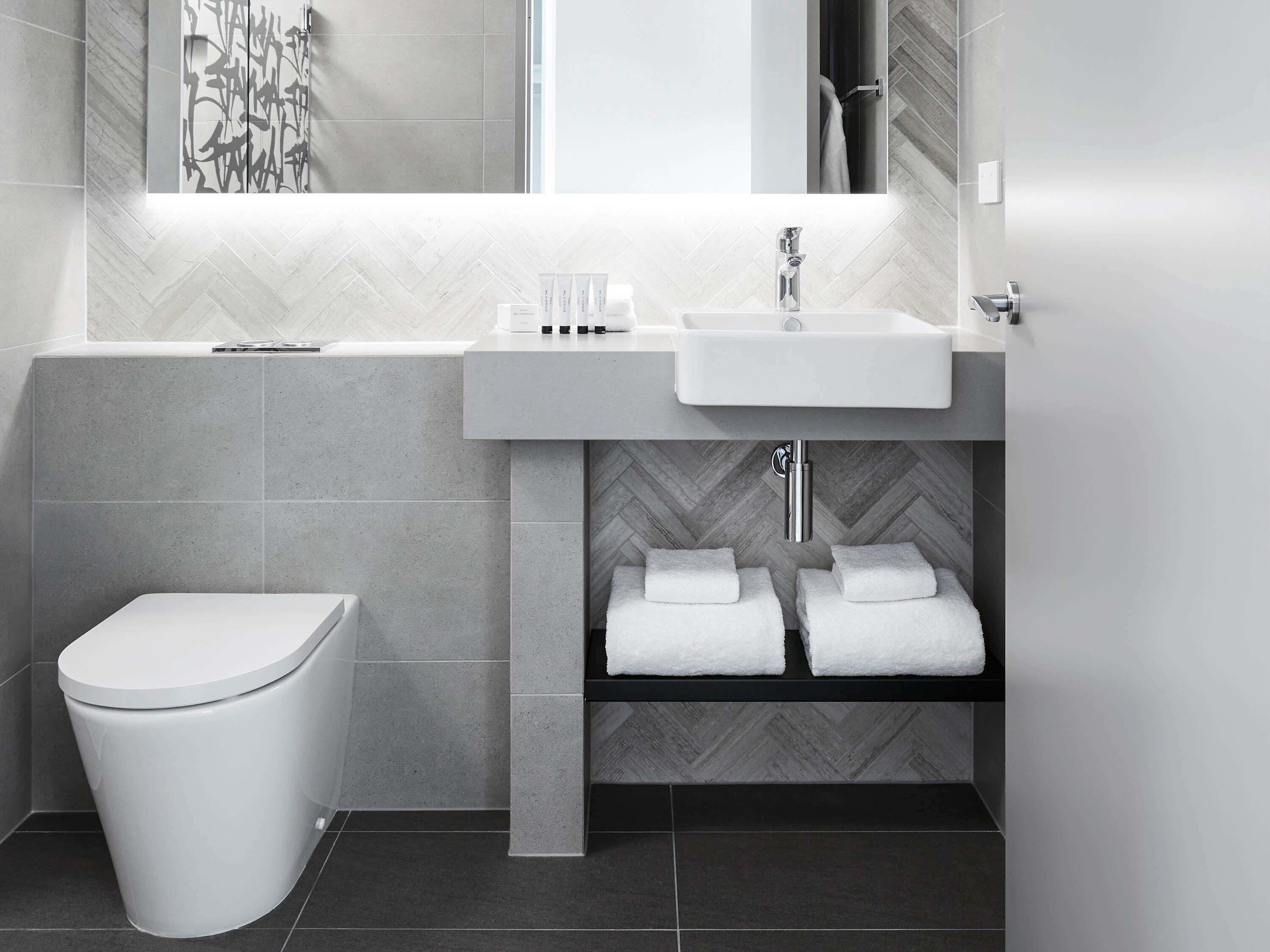 A modern bathroom with a toilet, sink, and shower area.