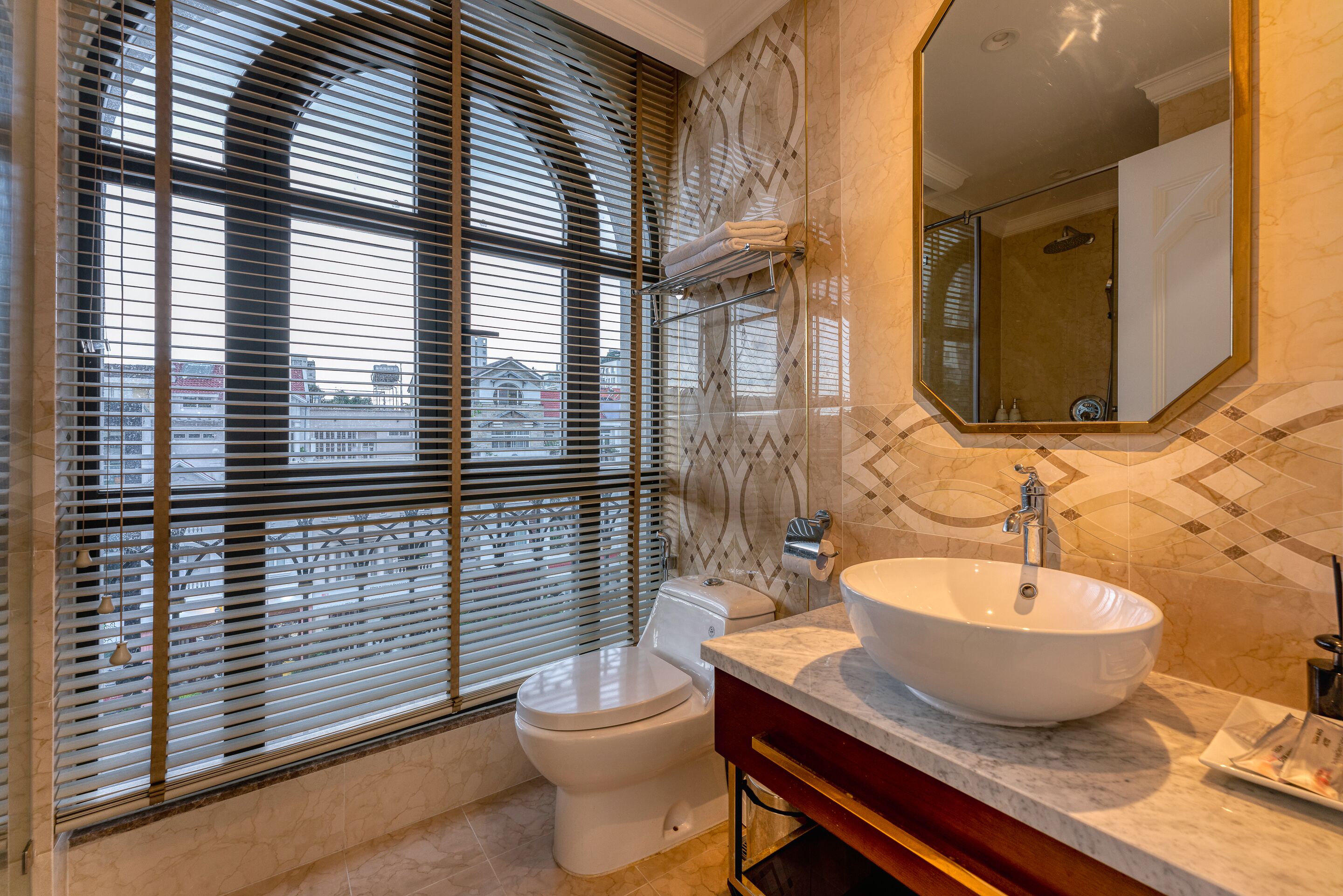 Ein modernes Badezimmer mit großem Fenster, Toilette, Waschbecken und Spiegel.