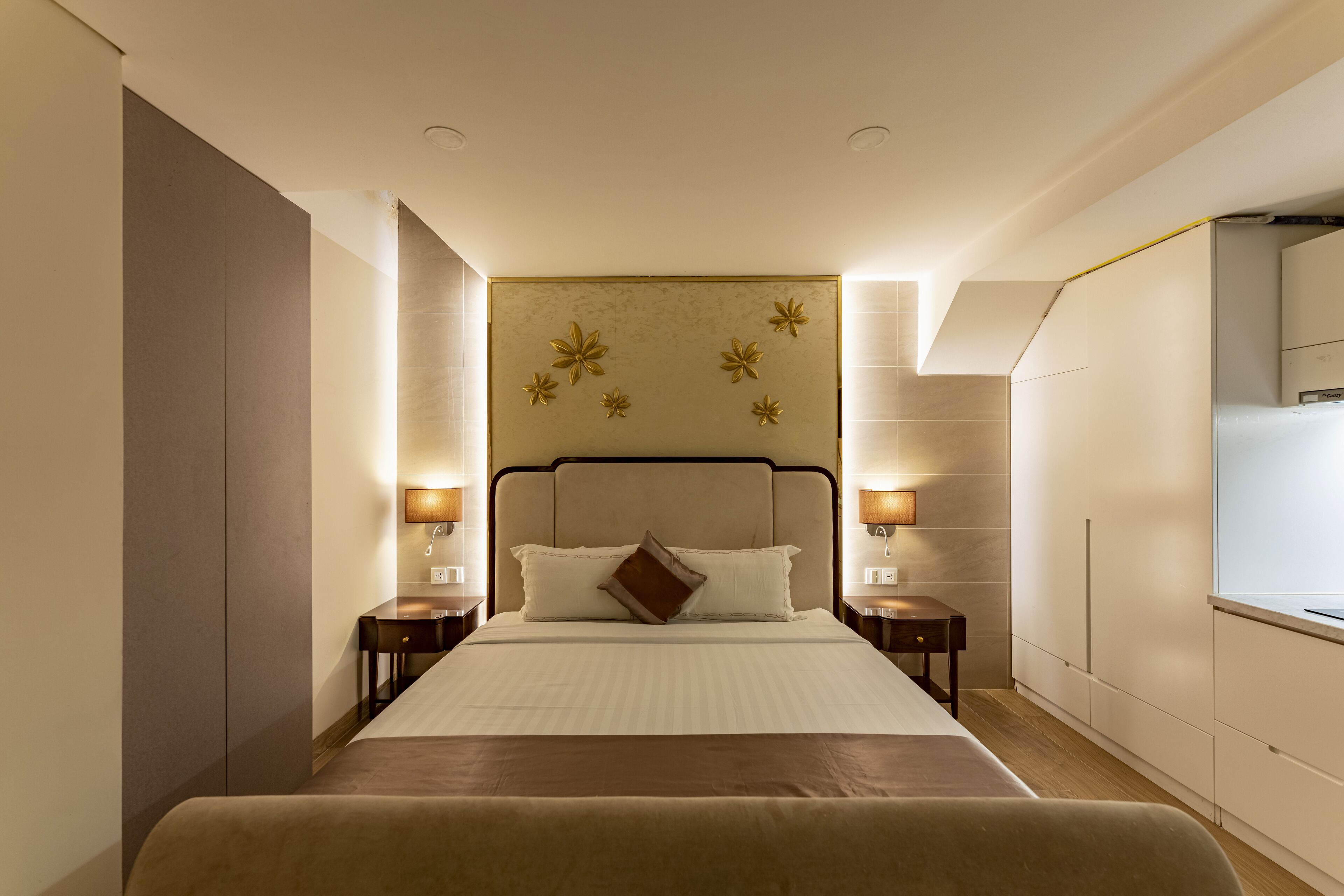 Una habitación de hotel con una cama grande, dos mesitas de noche y una mesilla.