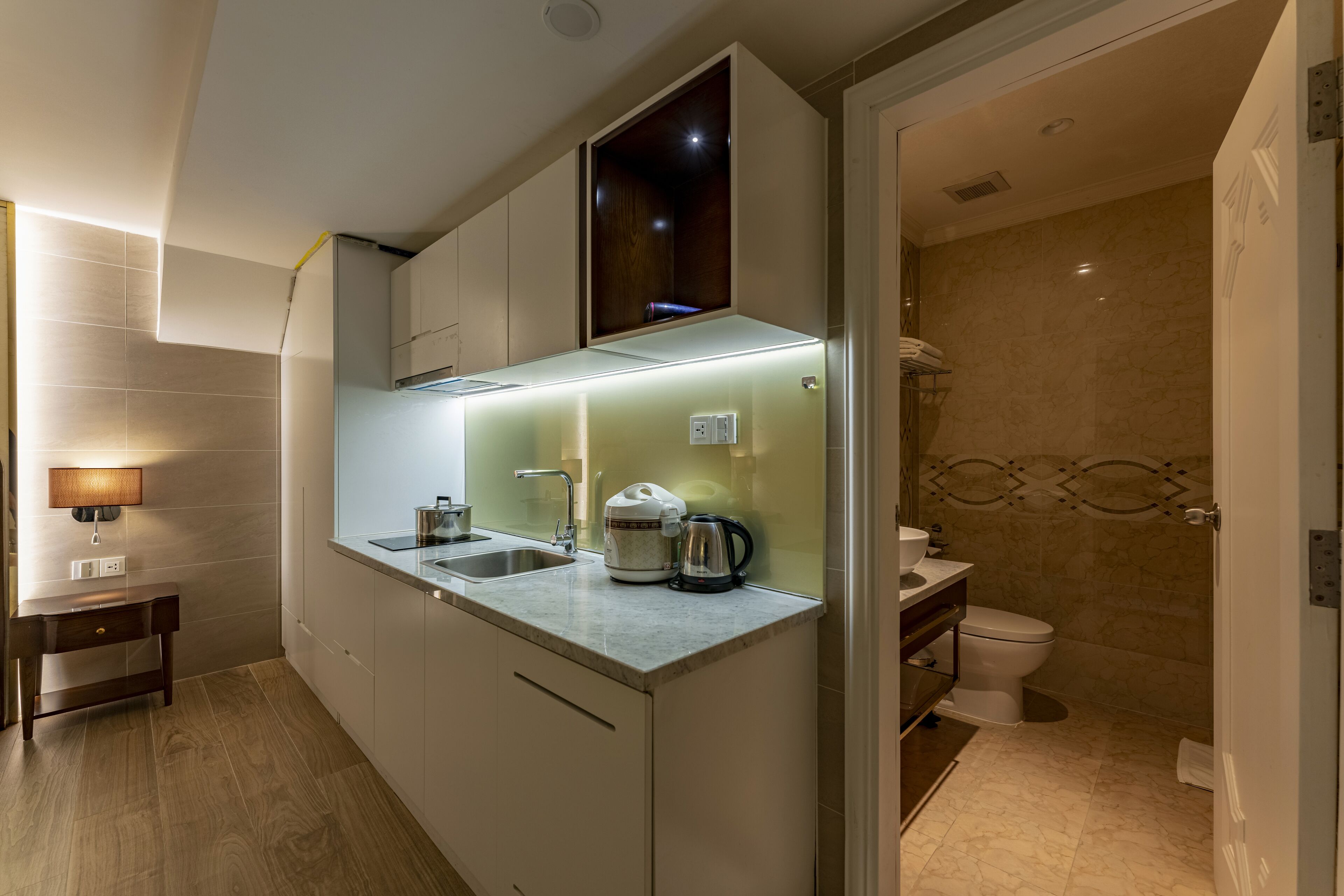 A modern kitchen with a built-in stove, a coffee maker, and a sink.
