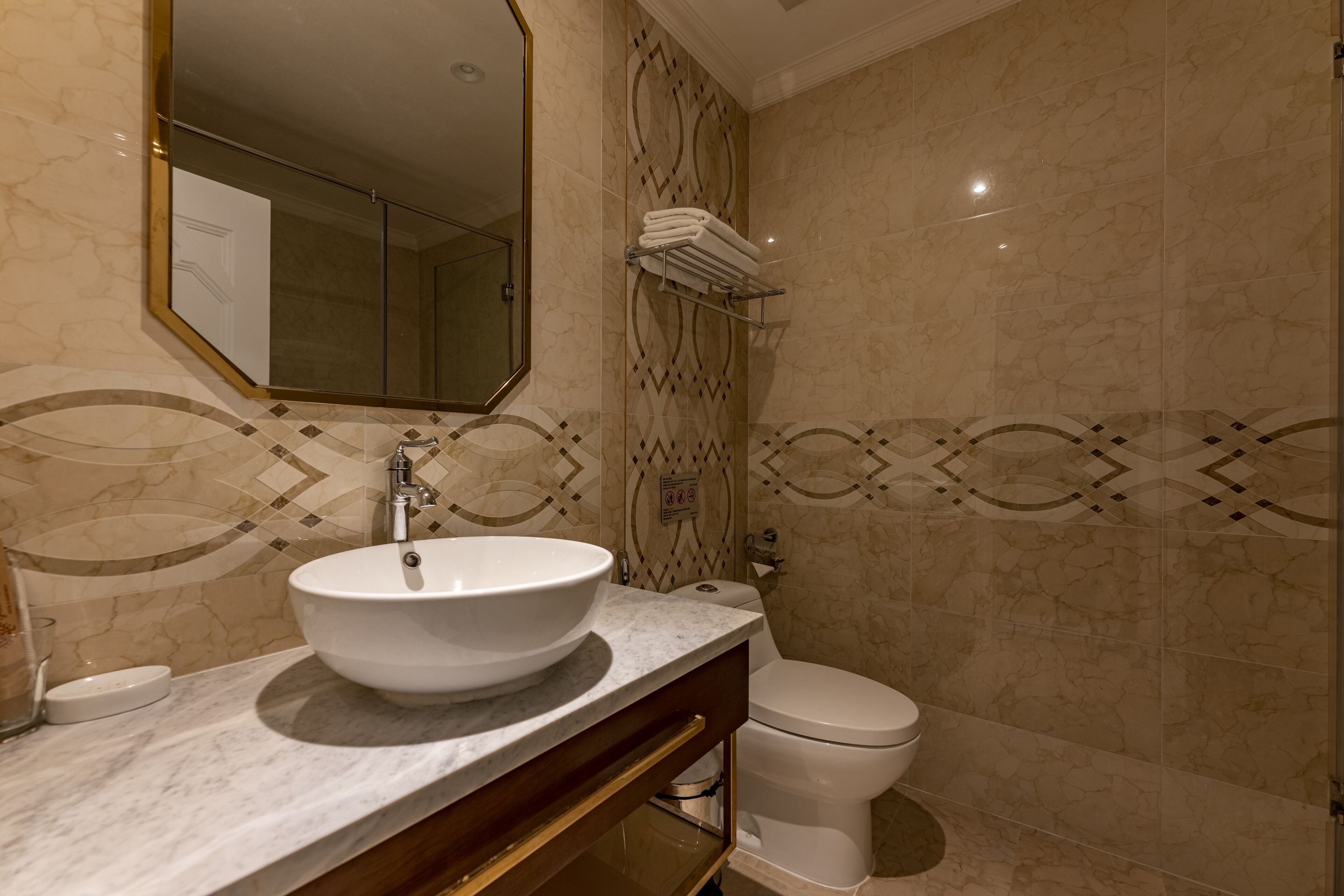 Un bagno con un lavandino bianco grande, uno specchio e un water.