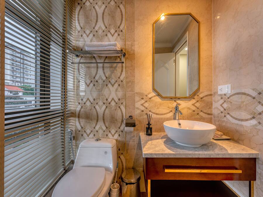 A bathroom with a toilet, sink, and mirror.