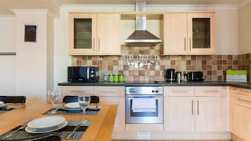 Full-sized fridge, oven, stovetop, cookware/dishes/utensils