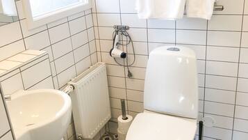 Ett badrum med toalett, bidé och handfat.