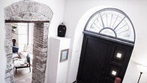 Contemporary space with a brick column and black door featuring a glass panel and metalwork.