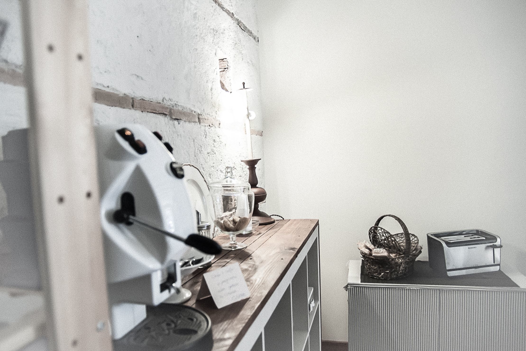 A kitchen with a coffee machine, a basket of bread, and a toaster.