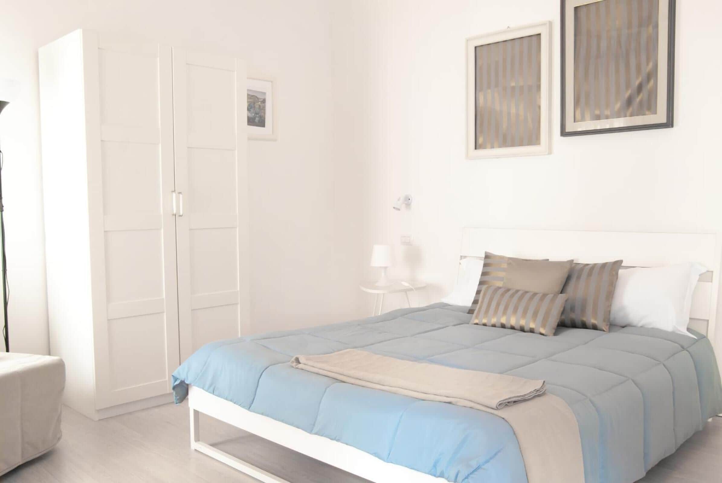 Una camera da letto con un letto, un armadio e un comodino.