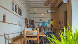 A cozy cafe with wooden furniture, a coffee machine, and a clock on the wall. - Bookbreakfast (Terme Vigliatore)