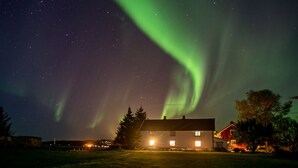 A house with a visible front porch and a well-lit exterior at night. - Klostergården Tautra (Frosta)