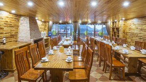 A restaurant with wooden interiors, multiple dining tables, and chairs. - Sapa Full House Hotel (Sa Pa)