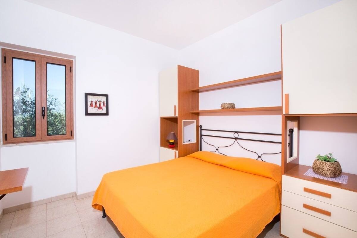 Une chambre à coucher avec un lit, un bureau et une fenêtre.