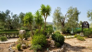 A landscaped garden with palm trees, rocks, and a sign for 'Residence Valle Verde'. - Residence Valleverde (Vieste)