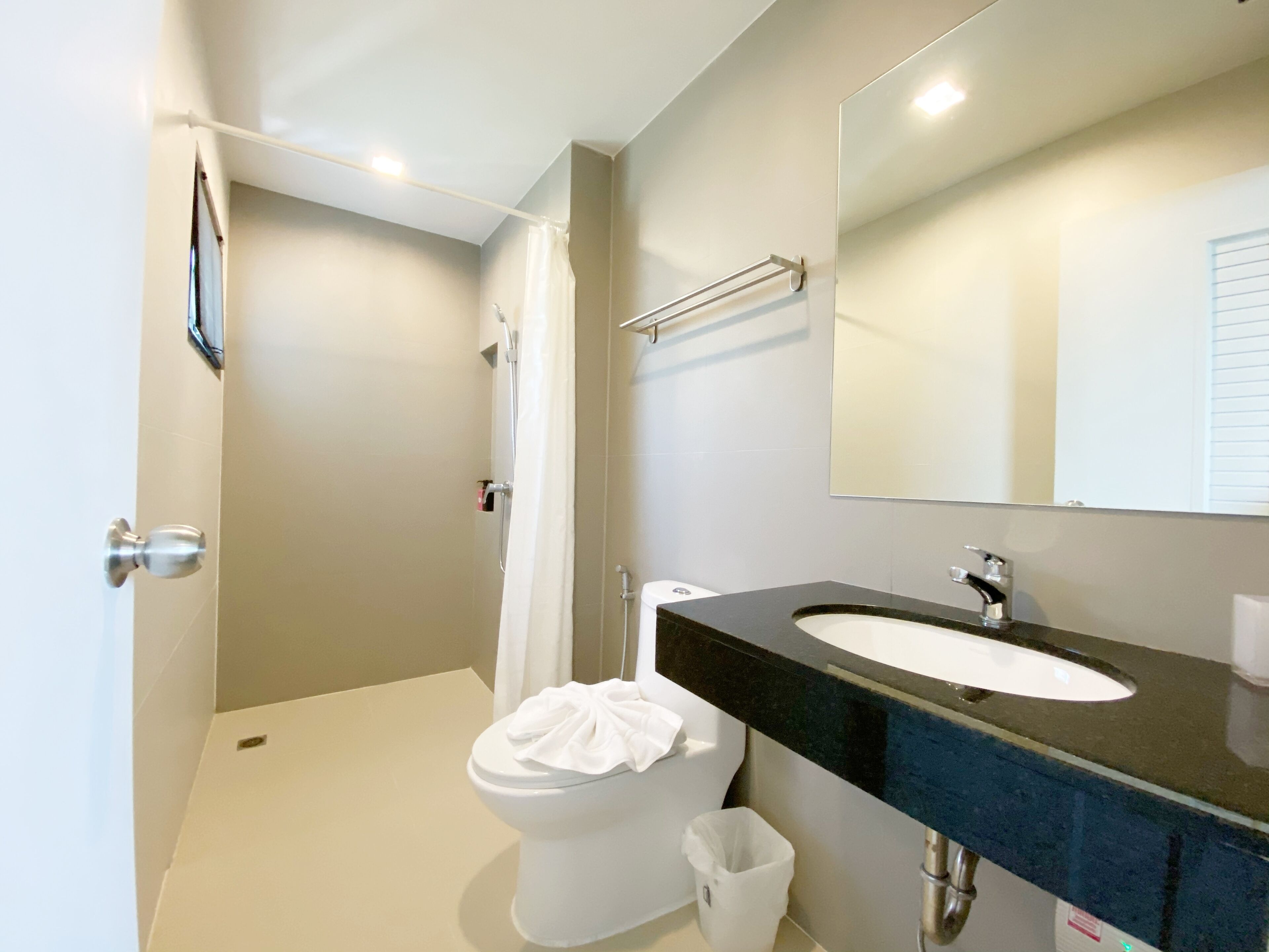A modern bathroom with a toilet, shower, and sink.
