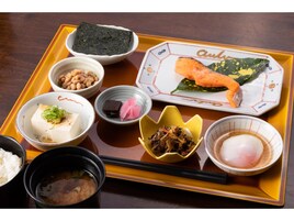 Una bandeja con diversos platos japoneses, incluyendo salmón, tofu y verduras encurtidas.