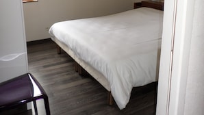Ein Schlafzimmer mit einem Bett, einem Schreibtisch und einem Fenster.