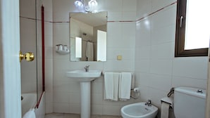 A bathroom with a sink, bidet, toilet, and a mirror. - Boncompte (Ponts)