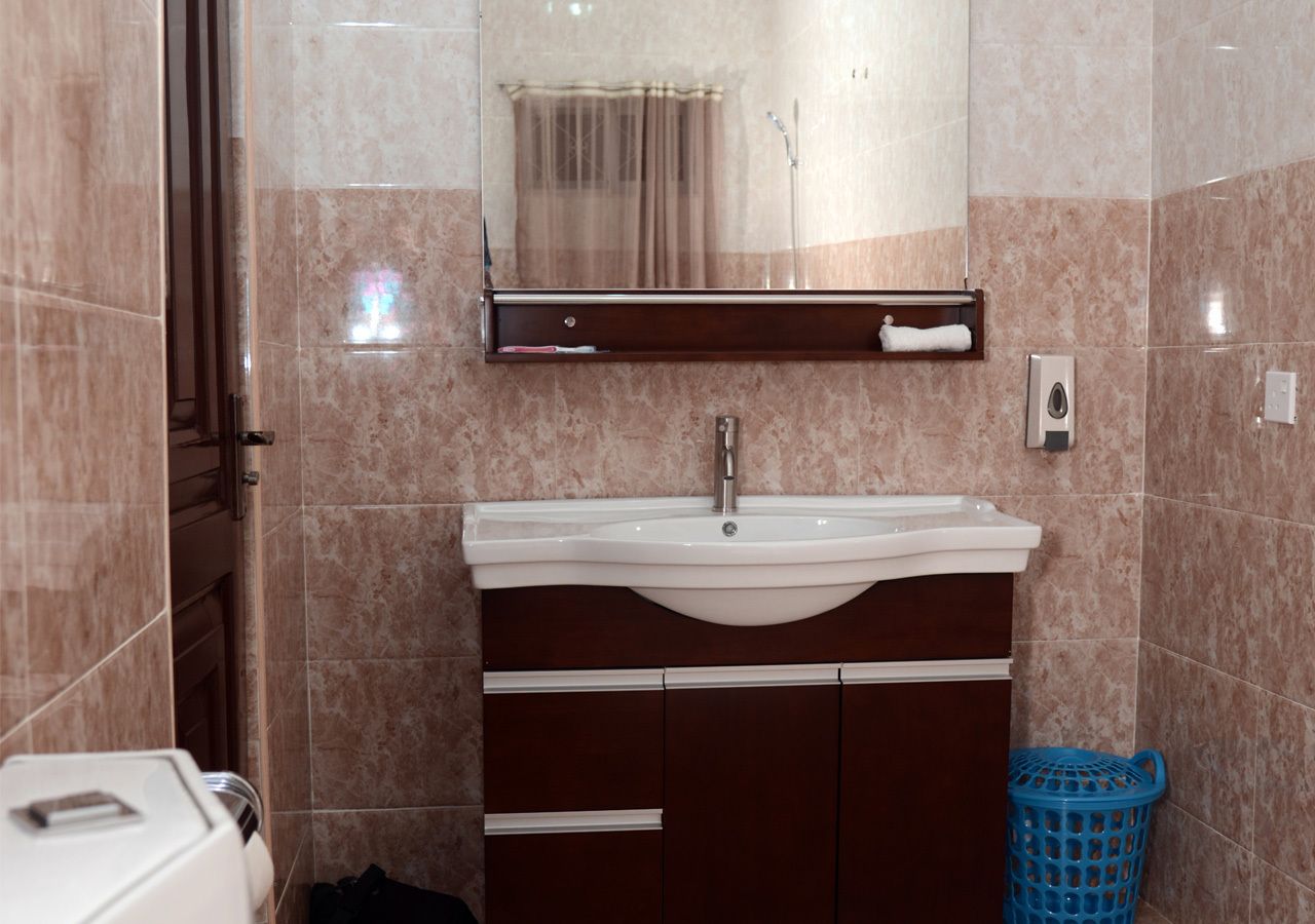 A bathroom with a sink, mirror, and towel rack.