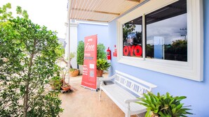 A building with a blue exterior, a white bench, and potted plants. - OYO 330 Venus Resort Pranburi (Pranburi)