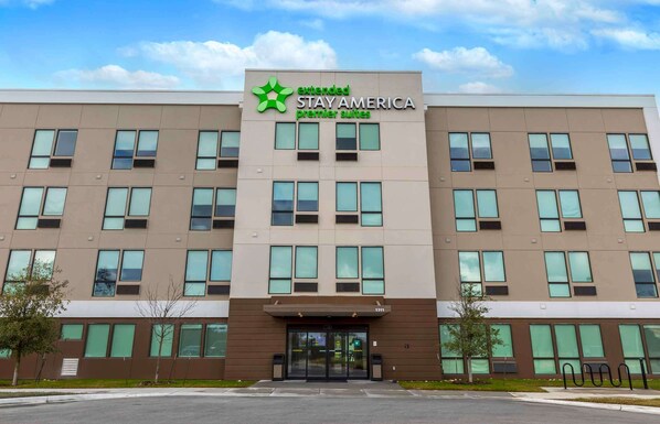 A multi-story hotel with a modern facade, featuring a prominent logo and signage for 'Extended Stay America Premier Suites'.