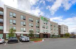 A StayAmerica hotel with a modern design, multiple floors, and a parking lot.