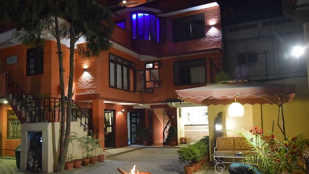 A courtyard with a fire pit, outdoor seating, and potted plants. - Hotel Siraaj Inn (Lalitpur)
