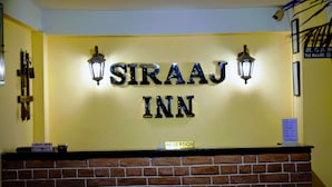 A reception area with a sign that reads "SIRAAJ INN" and a "RECEPTION" sign below it. - Hotel Siraaj Inn (Lalitpur)