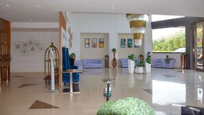 A modern lobby with a reception desk, seating area, and artwork on the walls.