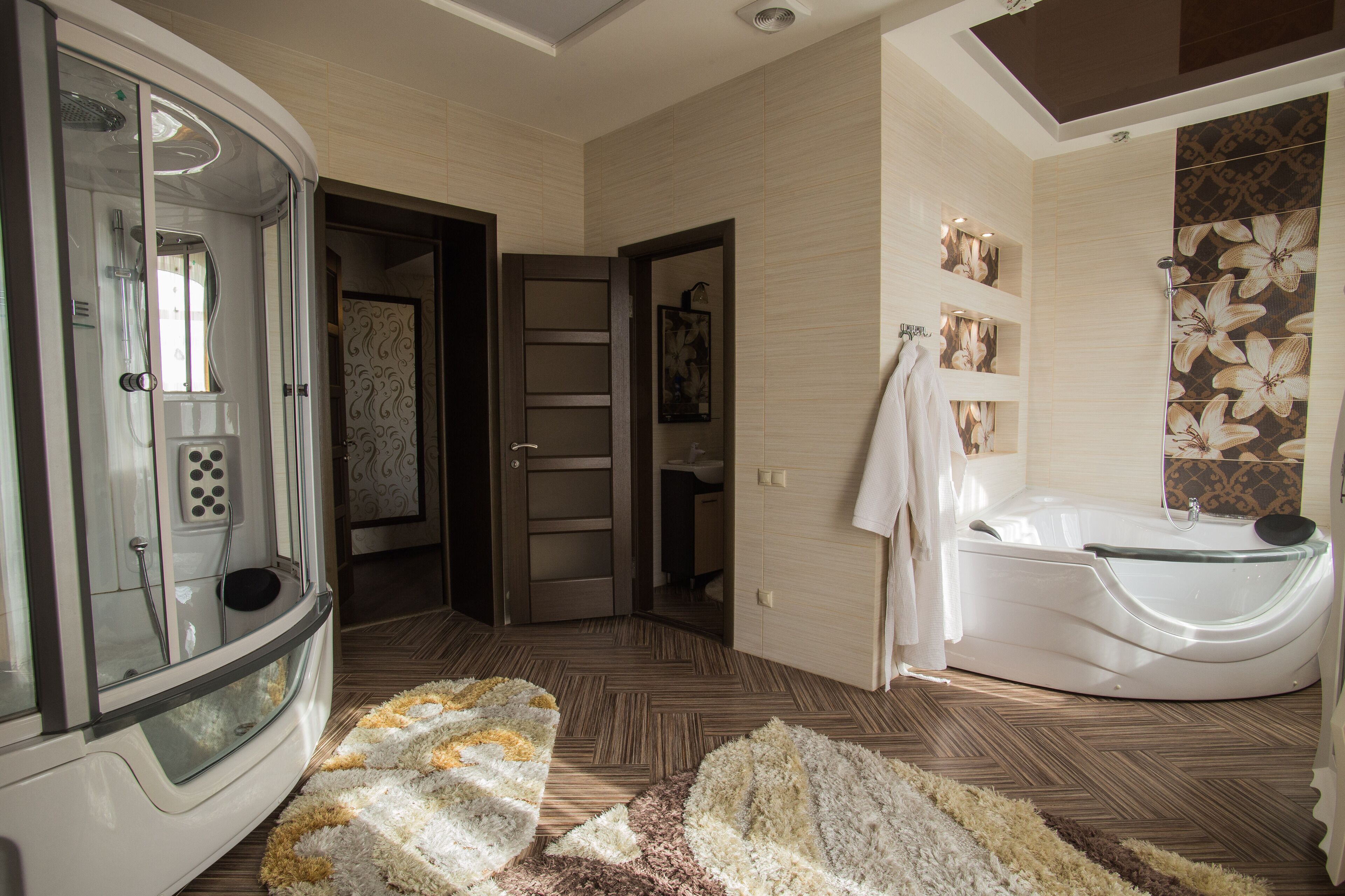 Un baño moderno con ducha a nivel de suelo, bañera independiente y cortina de ducha estampada.