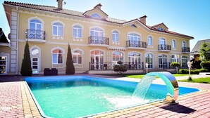 Un edificio grande de dos pisos con piscina y una cascada.