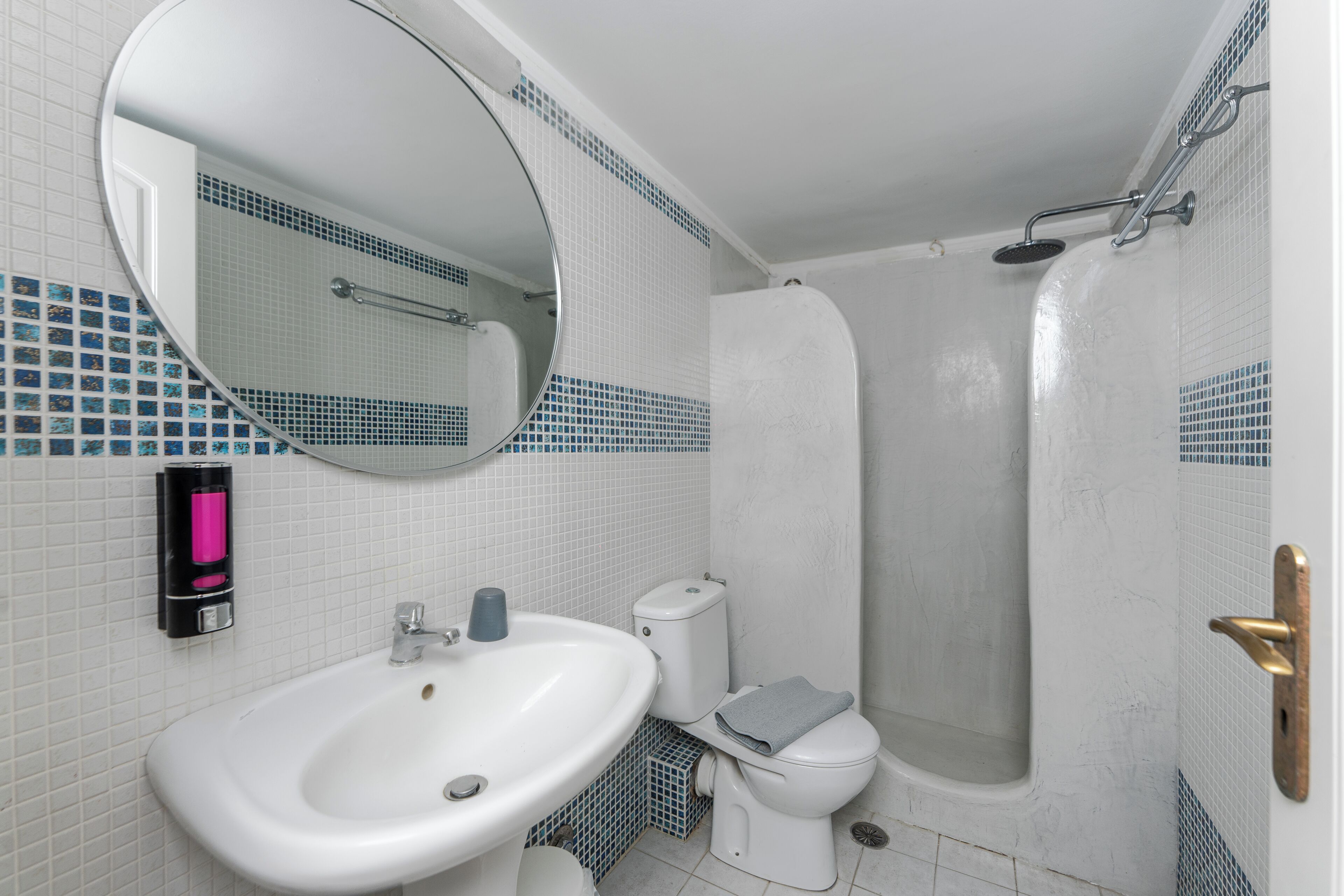 A bathroom with a sink, toilet, and shower.