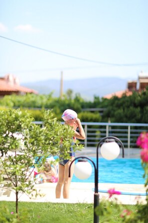Guests can enjoy a refreshing swim in the pool surrounded by lush greenery.