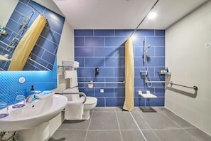 A bathroom with a blue tiled wall, a white sink, a toilet, and a shower area with a yellow shower curtain. - Holiday Inn Express Hangzhou Jiuzhou by IHG (Hangzhou)