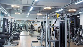A gym with various exercise equipment, mirrors, and a clean, organized layout.