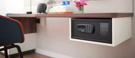 A modern kitchen with a built-in oven, a coffee machine, and a vase with flowers on the counter.