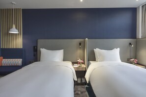 A hotel room with two beds, a bedside table with a lamp, a phone, and a small vase with flowers. - Holiday Inn Express Hangzhou Jiuzhou by IHG (Hangzhou)
