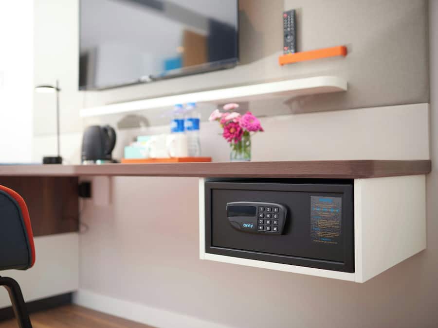 Eine moderne Küche mit Backofen, Kaffeemaschine und einer Blumenvase auf der Arbeitsplatte.