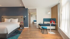 A modern hotel room with a large bed, a small desk, and a seating area. - Holiday Inn Express Hangzhou Jiuzhou by IHG (Hangzhou)
