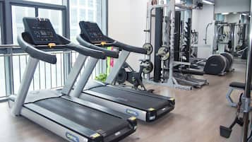 A gym with treadmills, weight machines, and a variety of fitness equipment.