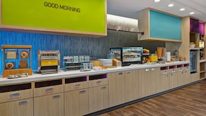 A breakfast bar with a 'Good Morning' sign, a 'Inspired Table' sign, and various breakfast items and utensils. - Home2 Suites Sarasota I-75 Bee Ridge, FL (Sarasota)