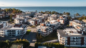 Ein Küstenwohngebiet mit modernen Wohngebäuden, einem Yachthafen und Blick auf das Meer.