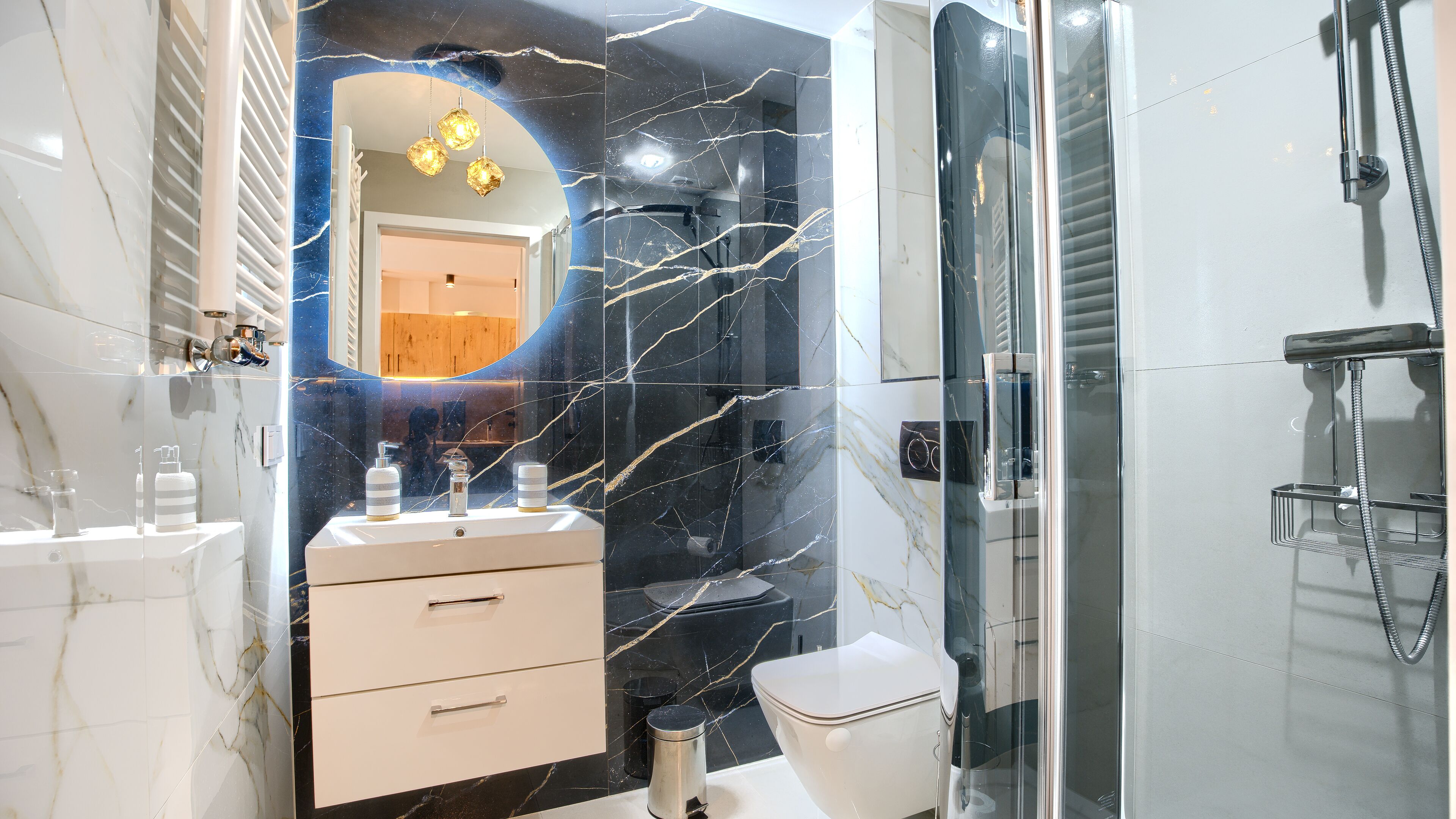 Ein modernes Badezimmer mit einem Marmor-Waschtisch, einer Toilette und einer Duschkabine.