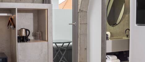 Un baño moderno con un espejo grande, un lavabo y una cabina de ducha de vidrio.